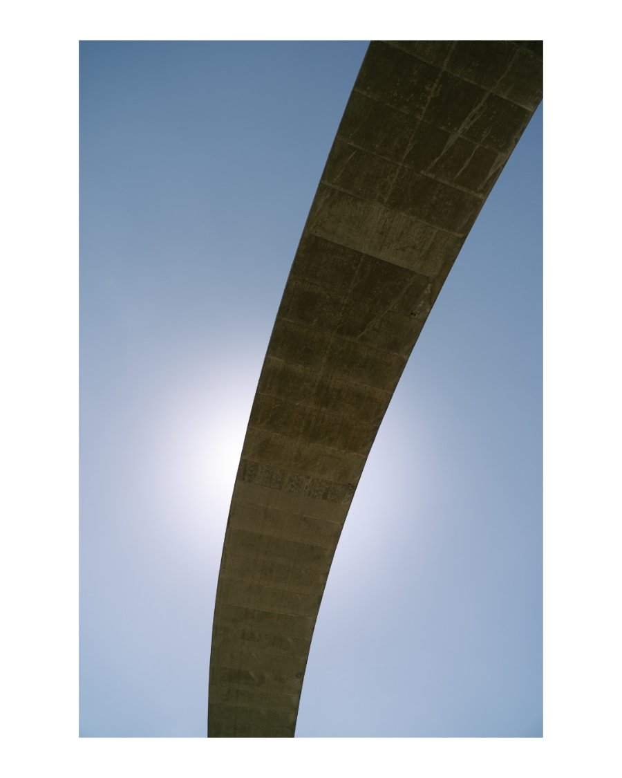 Concrete bridge arch against a bright blue sky