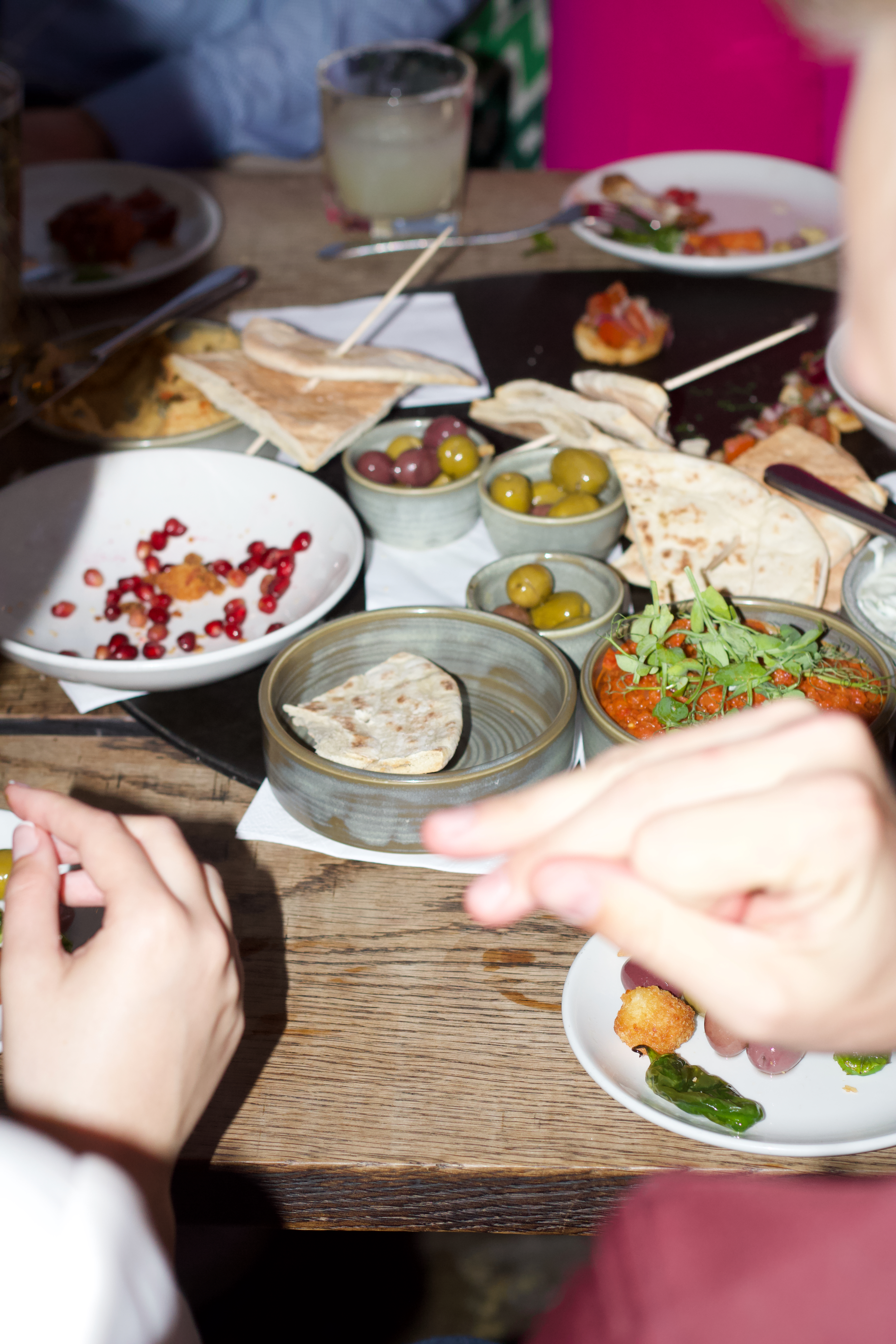 Shared plates on a restaurant table, mid meal